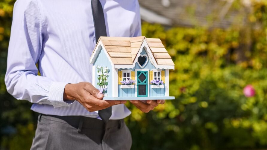 man holding a house model